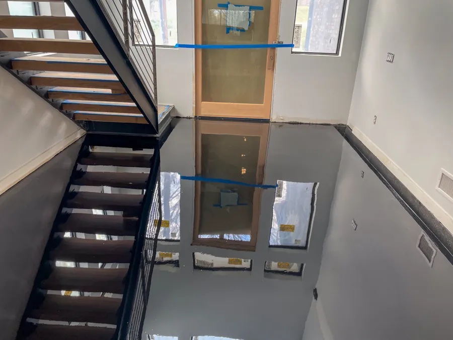 Glossy black epoxy entry floor by a staircase, industrial flooring serving Nashville, TN
